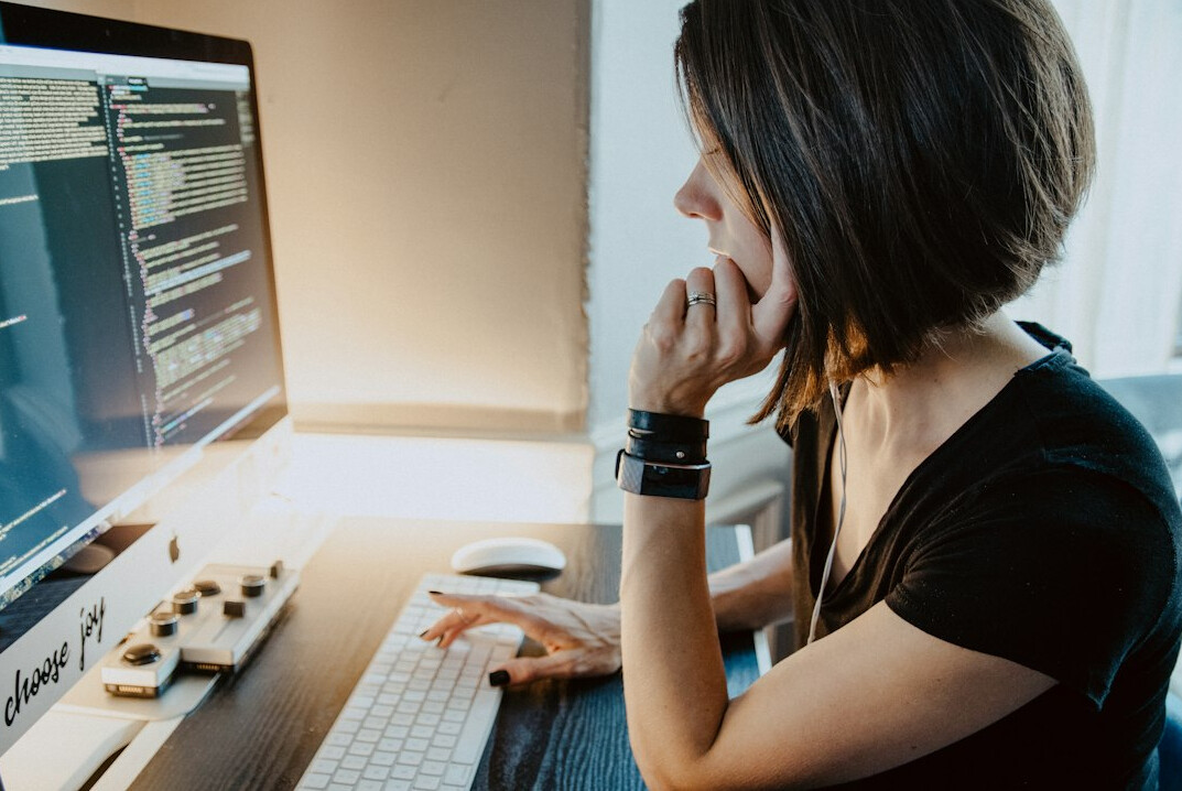 person writing code at desk